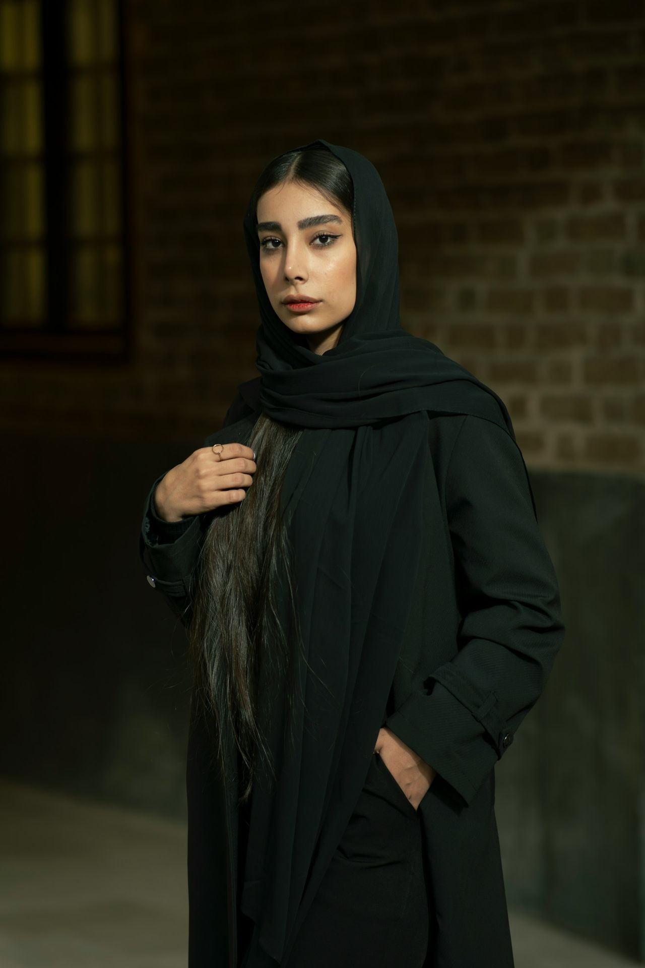 A woman wearing a black hijab and a black coat